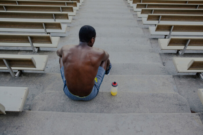 Runner sitting on stadium bleachers after training.